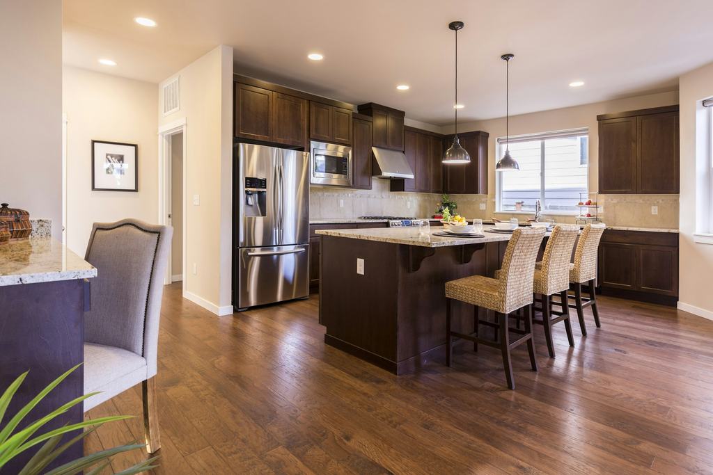 Updated kitchen with wood cabinets, a center island and hardwood floors