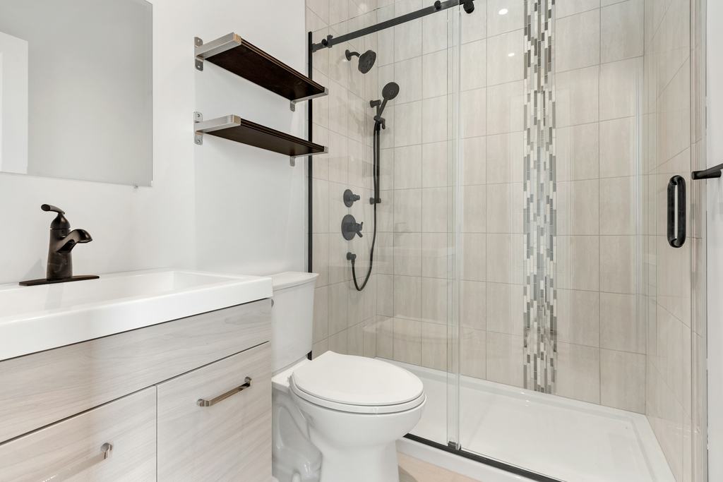 Bathroom with a tiled walk-in shower and vanity