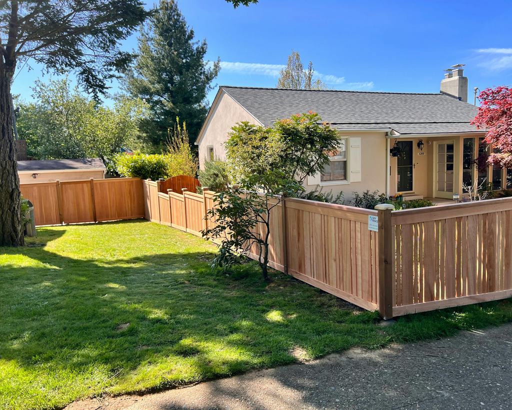 New wood fence around the backyard of a small house