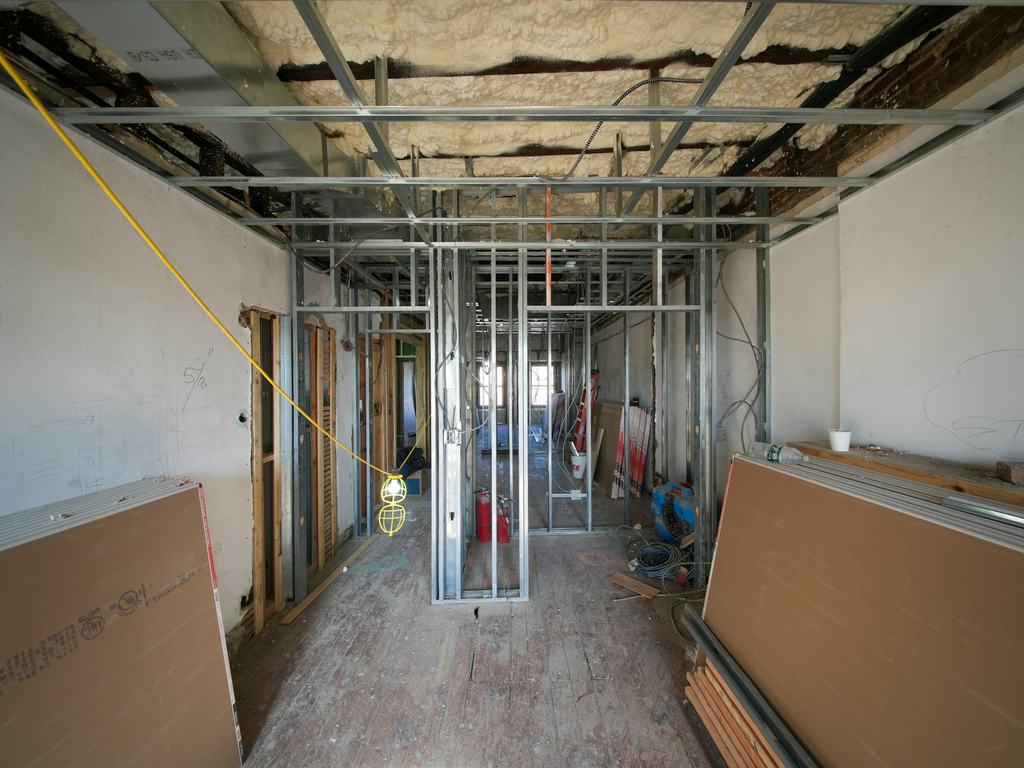 Small commercial interior being framed with metal studs and drywall
