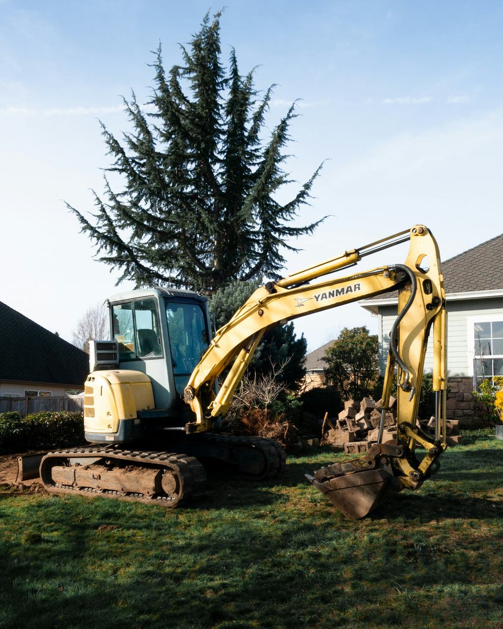 Compact excavator grading a residential yard