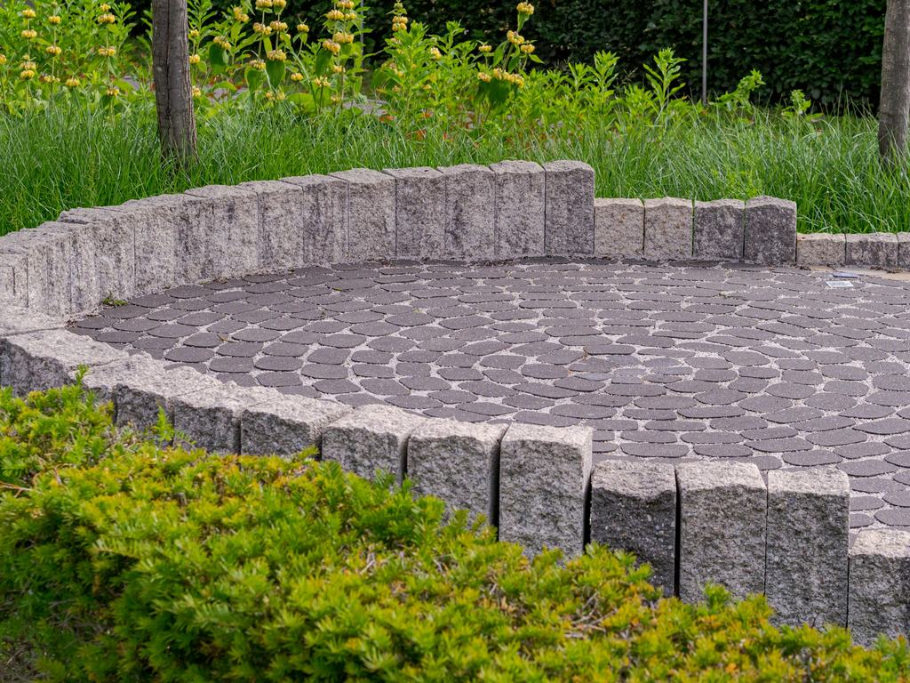 Circular paver patio edged with a low stone wall