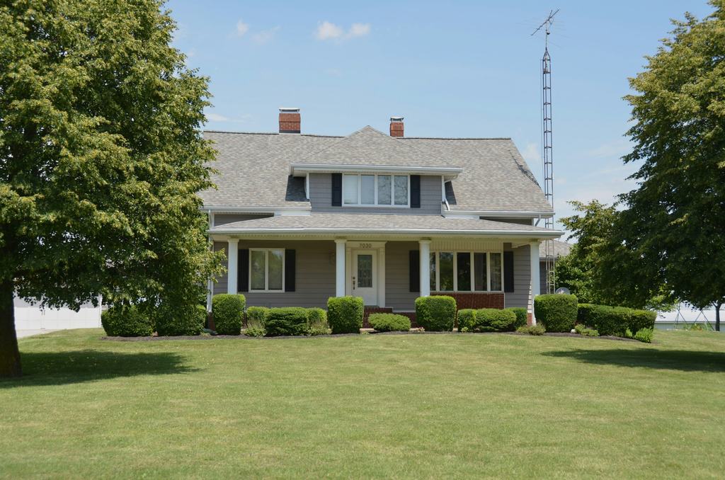 Two-story gray house with a covered front porch and lawn