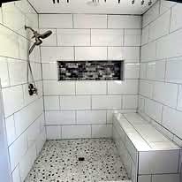 Tiled walk-in shower with a bench and a recessed niche