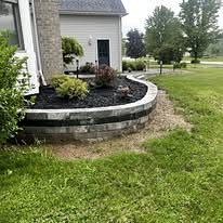 Raised block bed wall with plantings at the corner of the house