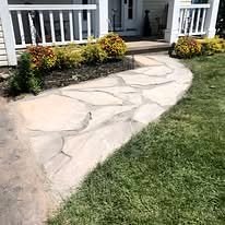 Flagstone walkway curving to a front porch, with new plantings