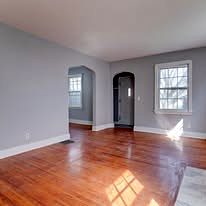 Room with arched doorways, fresh paint and hardwood floor