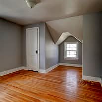 Upstairs room with a sloped ceiling and refinished hardwood floor